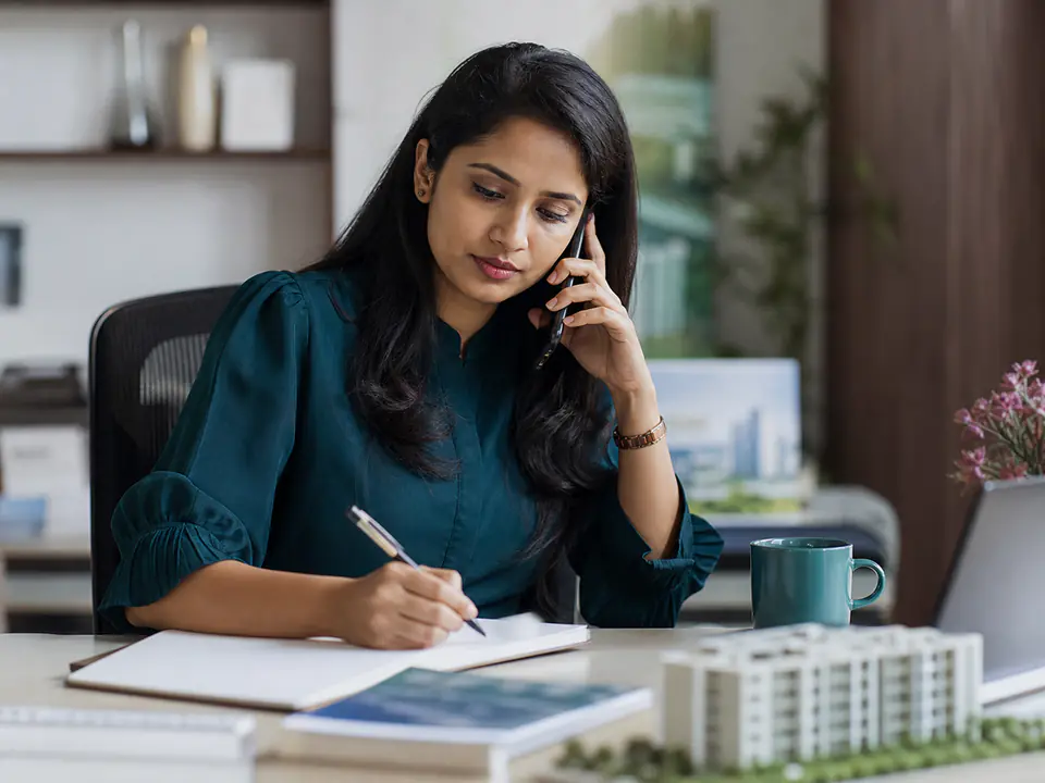 Indian property adviser listening to a caller and taking notes